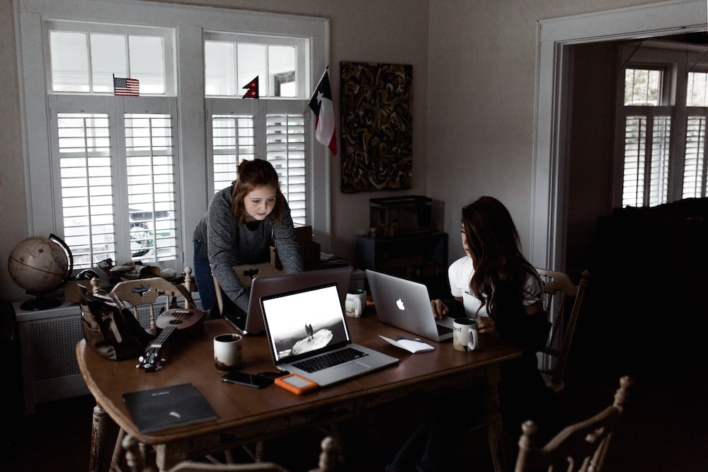 woman sitting on sofa while using MacBook Pro